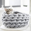 Panier original pour chat en maille tressée grise avec chat allongé à l’intérieur.