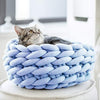 Panier original pour chat en tissu tressé bleu ciel avec chat installé.