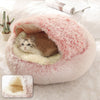 Chat blotti dans un panier fermé pour chat en peluche rose moelleuse.