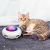Chat allongé près d’un jouet automatique pour chat à lumière LED.
