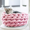 Panier original pour chat en rose pastel avec chat confortablement installé.