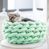 Panier original pour chat en maille tressée verte avec chat détendu.