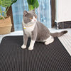 Tapis de Litière pour Chat - Chat gris assis sur le tapis anti-dérapant à côté d’une fenêtre.