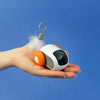 TurboMouse orange dans une main, jouet souris pour chat au format compact et interactif.