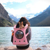 Sac à dos pour chat rose en randonnée face à un lac de montagne.