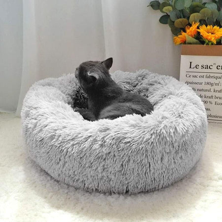 Panier Pour Chat gris clair avec chat noir lové à l'intérieur.