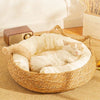 Chat blanc endormi sur un coussin crème dans un panier osier pour chat.