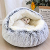 Chat blotti dans un panier fermé pour chat en peluche grise moelleuse.