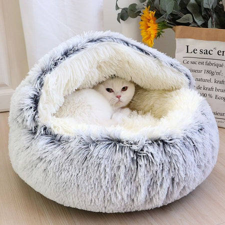 Chat blotti dans un panier fermé pour chat en peluche grise moelleuse.