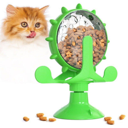 Chat roux léchant ses babines devant un Jouet Distributeur De Croquettes Pour Chat bien rempli..