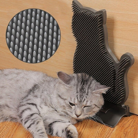 Chat détendu utilisant une brosse murale pour chat de couleur foncée.